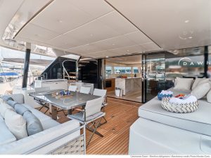 Pokład luksusowego katamaranu Sunreef Yachts z wygodnymi miejscami do siedzenia, stołem jadalnym i nowoczesnym designem.