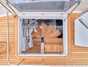 Widok z góry na luksusowy pokład katamaranu Sunreef Yachts z elegancką drewnianą podłogą i przytulnymi miejscami do siedzenia.