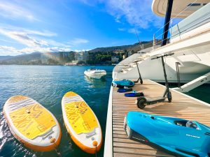 Luksusowy katamaran Sunreef Yachts zadokowany jest w marinie, obok znajdują się deski paddleboard i osobiste środki wodne.