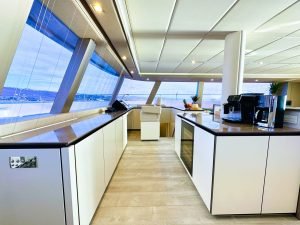 Wnętrze luksusowego katamaranu Sunreef Yachts z nowoczesną kuchnią o eleganckim wyglądzie.