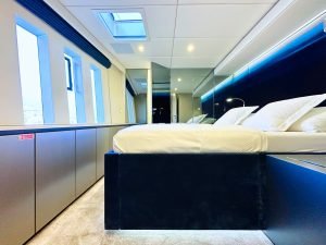 Widok wnętrza luksusowej kabiny Sunreef Yachts z łóżkiem i panoramicznymi oknami.