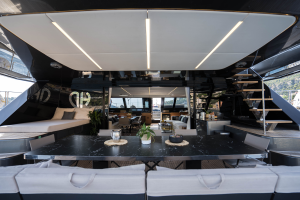 A luxurious Sunreef Yachts catamaran featuring an elegant outdoor dining area with a large marble table, cushioned seating, and modern design elements.