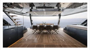 Obszar jadalny na luksusowym katamaranie Sunreef Yachts z nakrytym stołem do posiłku, otoczony nowoczesnym pokładem i z widokiem na ocean w tle.