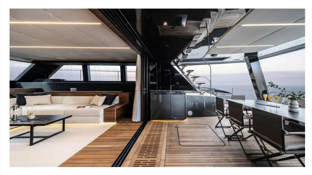 Wnętrze luksusowego katamaranu Sunreef Yachts z nowoczesnym salonem z sofami i stolikiem kawowym oraz otwartym pokładem z widokiem na morze.