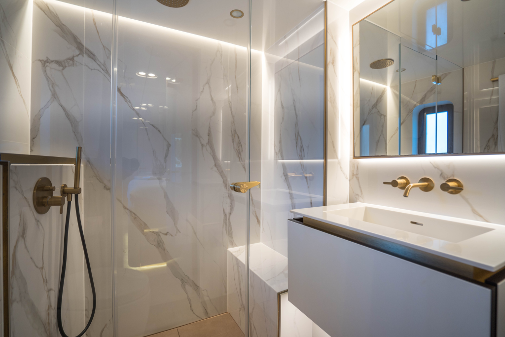 Luxurious bathroom with marble walls and a modern shower. It features elegant fixtures and a Sunreef Yachts design.