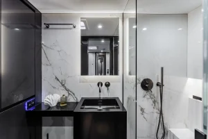 Luxurious and modern bathroom interior featuring marble walls, a black sink, and elegant fixtures aboard Sunreef Yachts.
