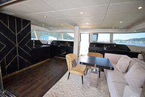 Wnętrze katamaranu Sunreef Yachts, pokazujące luksusową przestrzeń mieszkalną z eleganckimi meblami, nowoczesną kuchnią i dużymi oknami z widokiem na wodę.