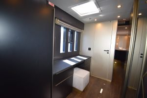 Wnętrze kabiny Sunreef Yachts z nowoczesnym designem, eleganckimi meblami, oknem i miękkim taboretem.