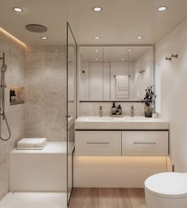 A modern yacht bathroom designed by Sunreef Yachts features a large mirror, double sink, and glass-enclosed shower. The decor includes elegant lighting and beige walls, with a set of towels neatly arranged on a shelf.