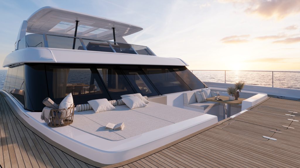 The Sunreef Yachts catamaran features a luxurious deck area with a sunbathing zone, comfortable cushions, and an outdoor table set against the backdrop of a serene ocean view at sunset.