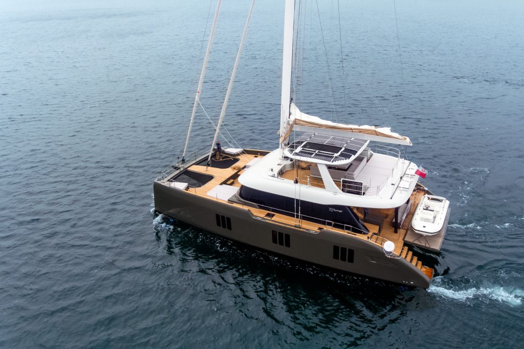 A luxurious Sunreef Yachts catamaran sails smoothly on calm waters, showcasing its elegant design and spacious deck.