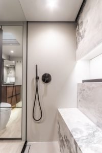 A luxurious bathroom interior on a Sunreef Yachts vessel, featuring elegant fixtures, marble details, and a spacious shower area.