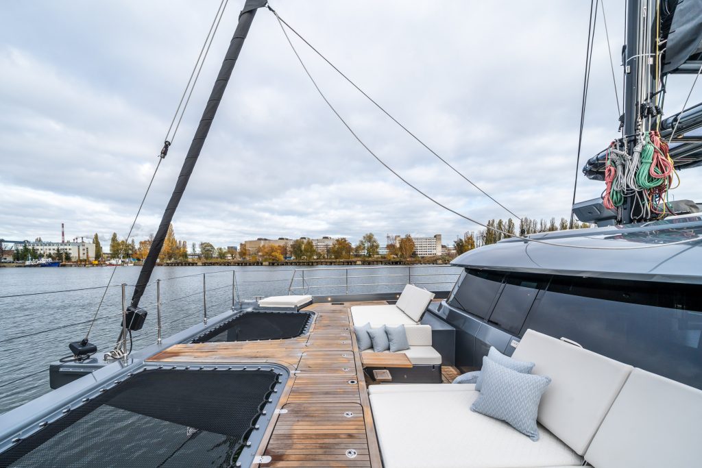 A luxurious Sunreef Yachts catamaran with a spacious deck including seating areas and views of a marina.