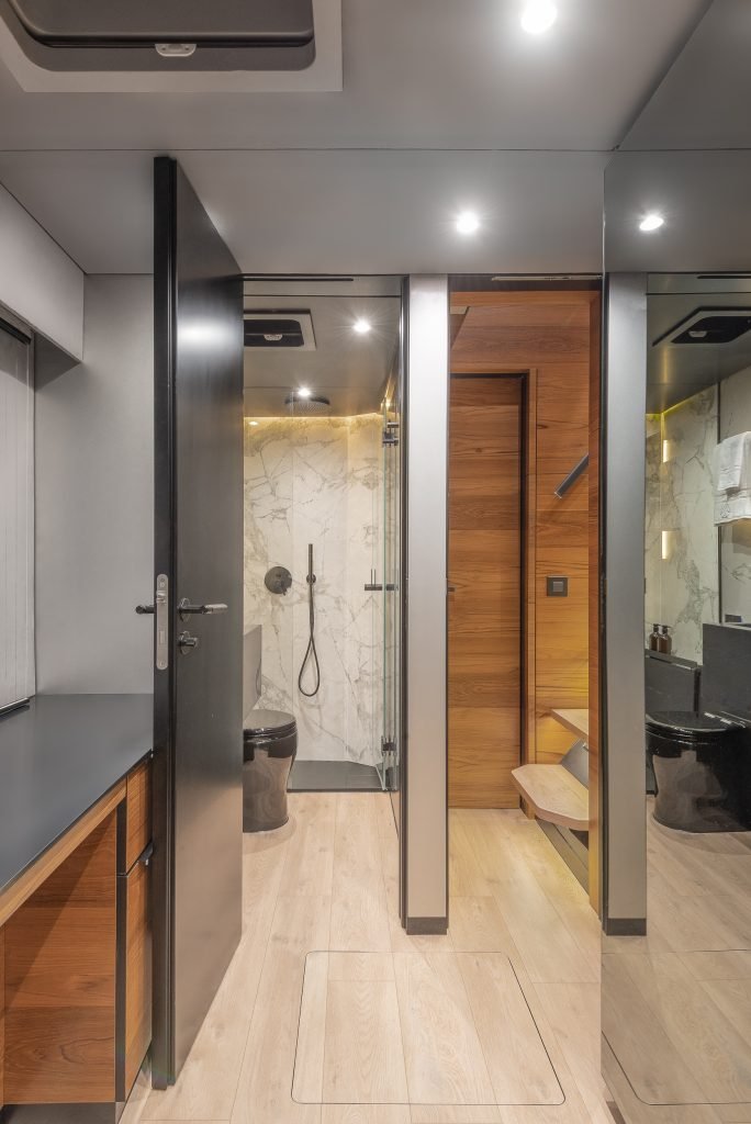 Interior of a luxury bathroom on a Sunreef Yachts vessel, featuring a sleek design with marble accents, wooden flooring, and modern fixtures.