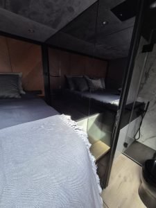 Interior view of a luxury bedroom on a Sunreef Yachts vessel, featuring elegant bedding and modern furnishings.