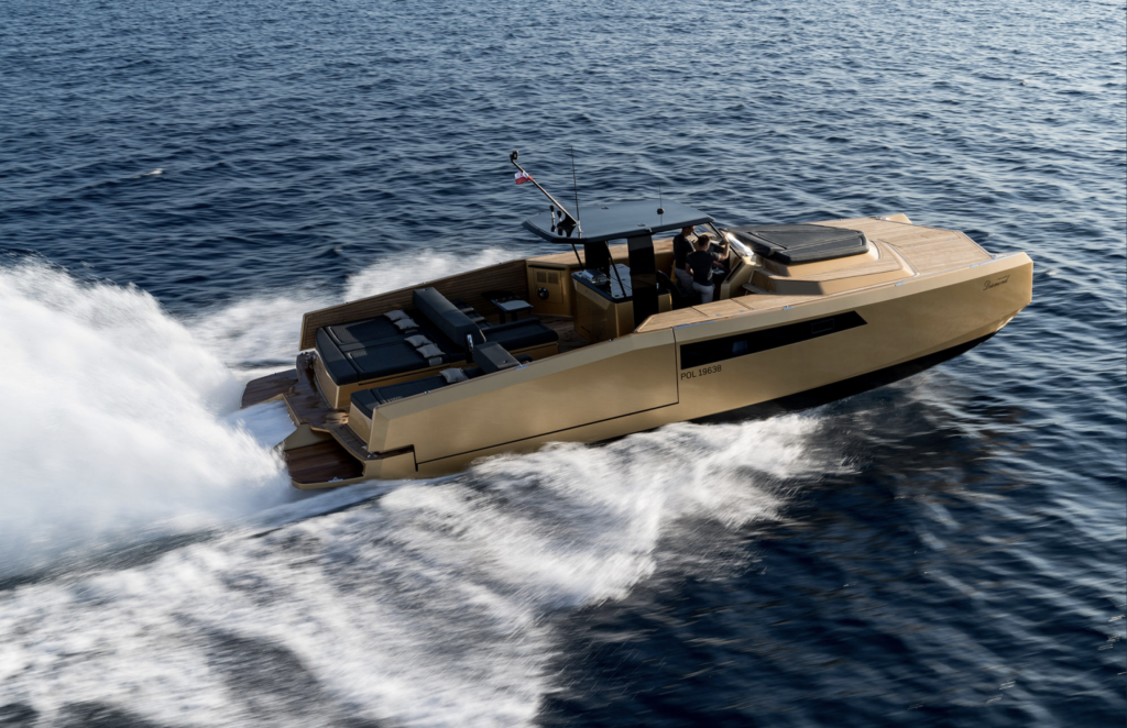 A Sunreef Yachts luxury motorboat glides swiftly over a calm sea, leaving a trail of white foam in its wake. The vessel features a sleek, modern design with a spacious deck area.
