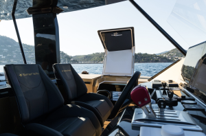 The image shows the cockpit and interior of a luxury yacht by Sunreef Yachts. There are multiple control panels and seats, with views of the water and shoreline in the background.